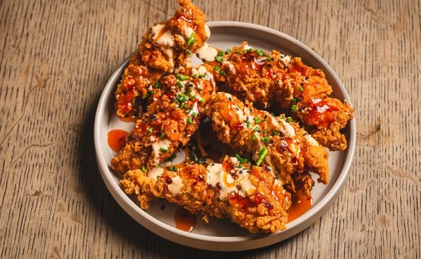 Hot Honey Tenders Tenders drizzled with hot honey and our house sauce. Garnished with chives and sesame seeds.